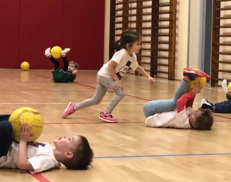 Dzieci ćwiczą z piłkami na zajęciach Akademii Sprawnego Dziecka